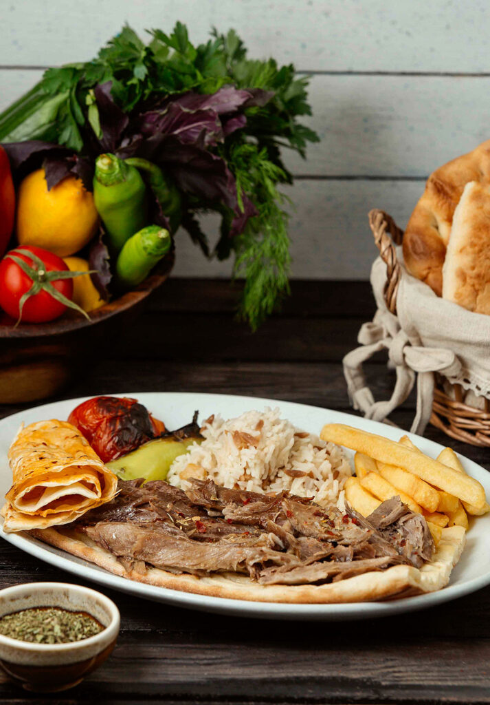 Beyaz tabakta et döner, pilav, patates ve pide sunumu – yemek fotoğrafçısı çekimi