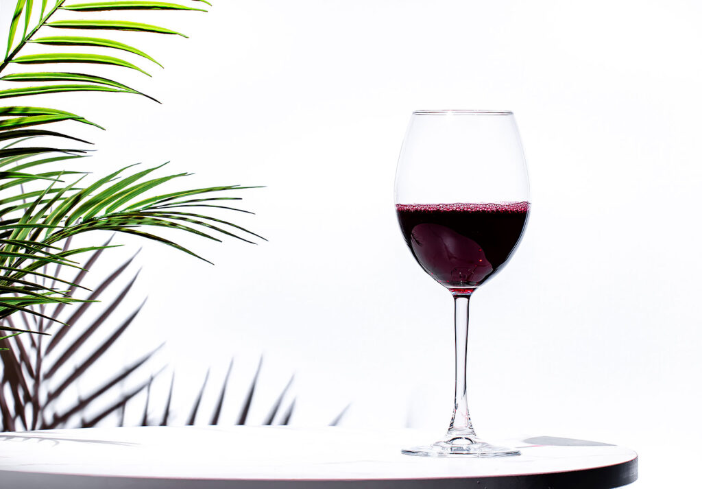 Kırmızı şarap şişesi ve cam kadeh ürün fotoğrafı