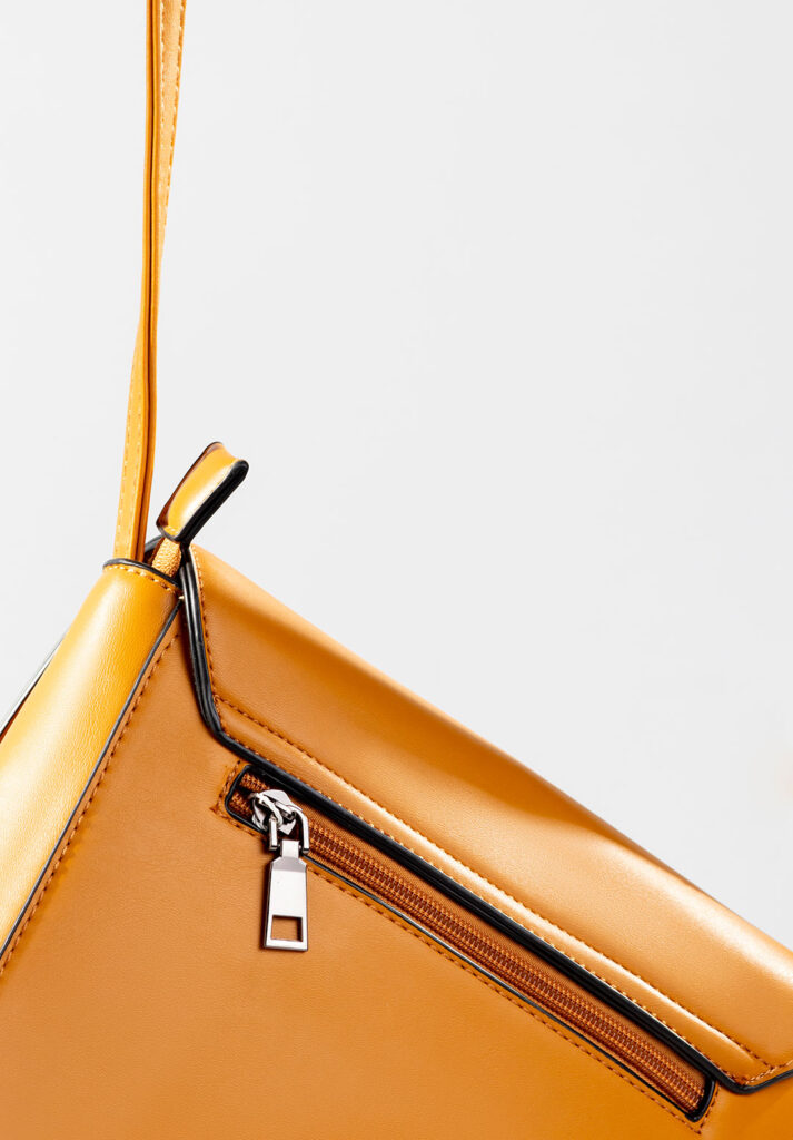 Sarı kadın çantanın fermuar ve dikiş detaylarını gösteren yakın plan ürün çekimi