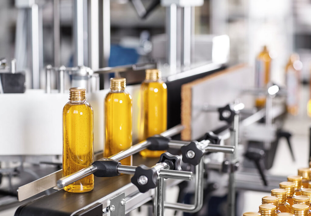 Fabrikada üretim hattında şişelere sıvı ürün dolduruluyor.