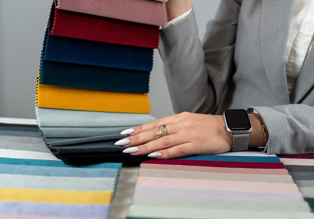 Tekstil sektöründe çalışan, farklı renk kumaş örneklerini inceliyor.