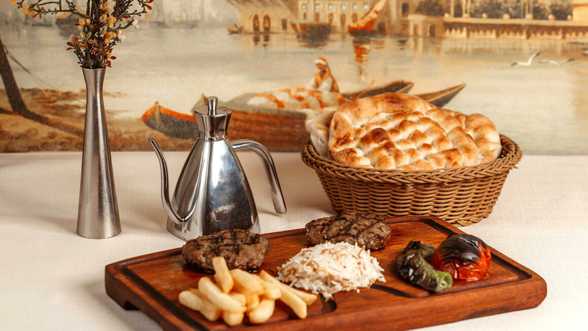 Ahşap tabakta köfte, pilav, patates ve pide sunumu – menü çekimi